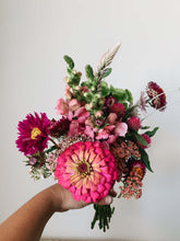 Load image into Gallery viewer, Miscellany + Co&#39;s Local Flower Bouquet subscription - a colorful monotone bouquet with barbie pink, hot pink, and light pink tones held up against a beige wall