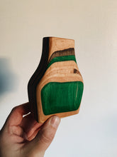 Load image into Gallery viewer, Vase made out of recycled skateboards held up against a white wall - green, maple, green, and black ply layers