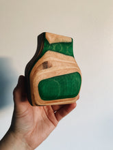 Load image into Gallery viewer, Vase made out of recycled skateboards held up against a white wall - green, maple, and green ply layers
